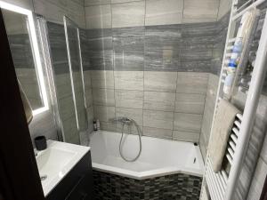a bathroom with a bath tub and a sink at Modern apartment in center of Prešov - Apartmán Boncart in Prešov +20 photos