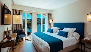um quarto de hotel com uma cama grande e uma varanda em Aiguablava Luxury Apartments em Begur