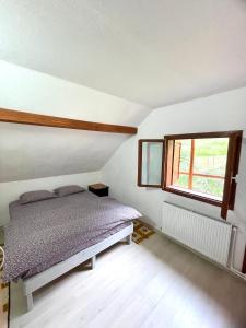 une chambre avec un lit et une fenêtre dans l'établissement Gyimesi kulcsosház / Casa de vacanta Ghimes, à Lunca de Sus
