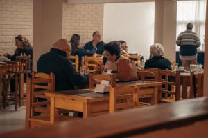 a group of people sitting at tables in a restaurant at Hotel Palma de Mallorca in La Paloma
