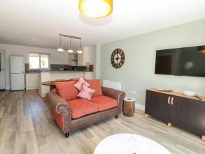 a living room with a couch and a kitchen at Rose Lodge in Alnwick
