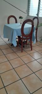 a table with two chairs and a blue table cloth at Hotel Happy House in San Salvador