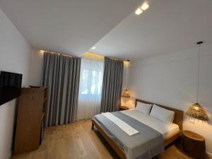a bedroom with a bed and a large window at Kanes Boutique Hotel in Sarandë