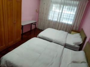 Sibu kulas homestay في سيبو: غرفة بسريرين ومكتب ونافذة