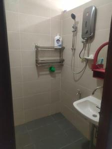 ein kleines Bad mit einem Waschbecken und einer Dusche in der Unterkunft Sibu kulas homestay in Sibu