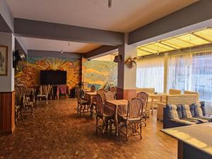 solsticio hostel في كوباكابانا: غرفة طعام مع طاولات وكراسي وتلفزيون