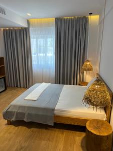 a bedroom with a large bed and a window at Kanes Boutique Hotel in Sarandë