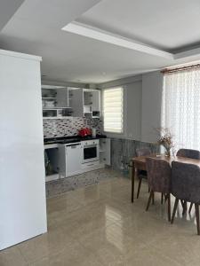 sala de estar con mesa y cocina en Villa DIEMEN en Uzumlu