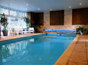 - une piscine d'eau bleue dans une maison dans l'établissement Maison d'Hôtes du Domaine Fournié, à Tarascon-sur-Ariège