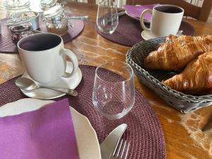 a table with a cup of coffee and croissants on it at Maison d'Hôtes du Domaine Fournié in Tarascon-sur-Ariège