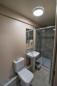 a bathroom with a toilet and a sink and a shower at Morecambe Rooms in Morecambe