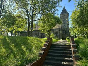 an old church with a steeple and stairs in front at Stunning 1-Bed Studio in Pudsey in Pudsey