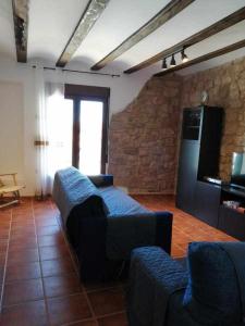 a living room with a couch and a tv at Casa Las Torres in Mora de Rubielos