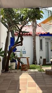 une terrasse avec des arbres, une table et une maison dans l'établissement Garden-Goretti House, à Mairena del Aljarafe