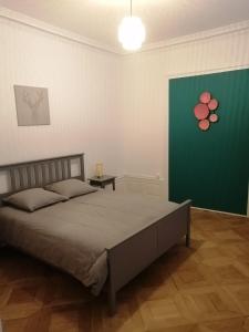 ein Schlafzimmer mit einem Bett und einer grünen Wand in der Unterkunft LE 1 " GÎTES TOUT CONFORT à COLMAR CENTRE" in Colmar