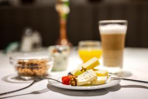 a plate of food on a table with two drinks at Hotel Monopol Luzern in Lucerne