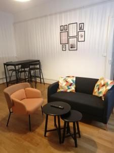 ein Wohnzimmer mit einem Sofa, einem Stuhl und Tischen in der Unterkunft LE 1 " GÎTES TOUT CONFORT à COLMAR CENTRE" in Colmar