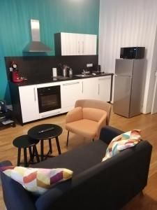 ein Wohnzimmer mit einem Sofa und einer Küche in der Unterkunft LE 1 " GÎTES TOUT CONFORT à COLMAR CENTRE" in Colmar