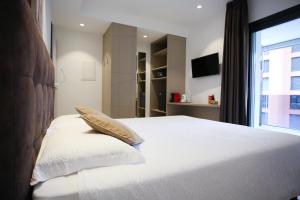 a bedroom with a large white bed with a window at Hotel Bellavista Locarno in Locarno