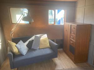 ein Wohnzimmer mit einem blauen Sofa und einer Lampe in der Unterkunft Ahoy London in London