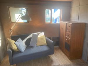 a living room with a blue couch and a lamp at Ahoy London in London