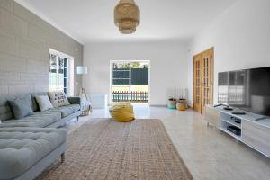 a large living room with a couch and a tv at Beautiful Villa in Sunny Lagoa in Sesimbra