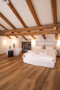 a bedroom with a large bed and a bath tub at Škerlj Wine Estate in Tomaj