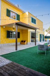 une maison jaune avec un banc devant elle dans l'établissement Beautiful Villa in Sunny Lagoa, à Sesimbra
