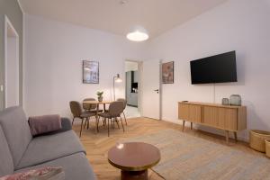 ein Wohnzimmer mit einem Sofa und einem Tisch in der Unterkunft limehome Vienna Karajangasse in Wien