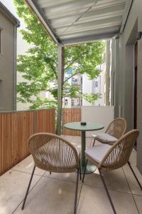 un patio con sillas, una mesa y una mesa con sillas en limehome Vienna Karajangasse en Viena