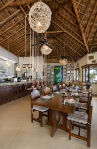 a dining room with a large wooden table and chairs at Grand Slam Fishing Lodge Tulum in Punta Allen