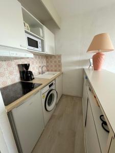 a small kitchen with a washer and dryer in it at Réf 543, Seignosse Océan, Appartement avec aperçu Mer, à 150m de la plage, 4 personnes in Seignosse