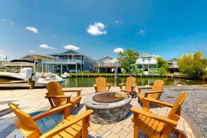 a group of chairs sitting on a patio next to the water at Town of Fenwick Island - 41 Bayside Dr in Fenwick Island