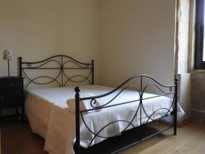 a bedroom with a bed with a black metal frame at Casa da Aldeia MGS in Laundos
