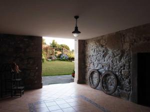 a hallway with a stone wall with two baskets on the wall at Casa da Aldeia MGS in Laundos
