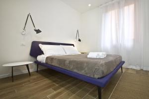 a bedroom with a blue bed with a table and a window at Corte Spagnola in Verona