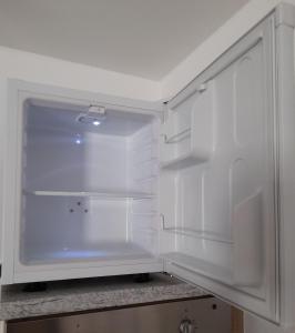 una nevera blanca con la puerta abierta en una cocina en Eltinger Studio Apartment, en Leonberg