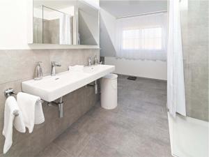La salle de bains blanche est pourvue d'un lavabo et d'un miroir. dans l'établissement Exklusive 5,5 Zimmer Wohnung für Familien und Business, à Eschenz