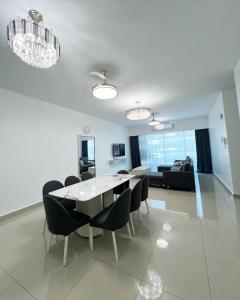 a dining room and living room with a table and chairs at SDC Suite Home in Lahad Datu