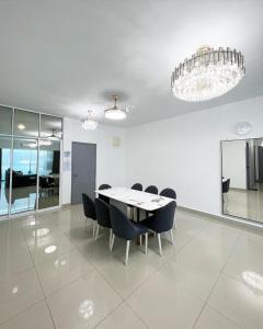 a dining room with a table and chairs and a chandelier at SDC Suite Home in Lahad Datu