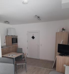 sala de estar con mesa y puerta blanca en Eltinger Studio Apartment, en Leonberg