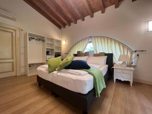 a bedroom with a large bed with a wooden headboard at Steba House Savani Barbara Foresteria Lombarda in Lonato