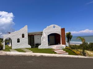 ein weißes Gebäude an der Straßenseite in der Unterkunft Casa de Playa Koumpí Beach in Don Juan