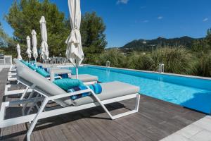 a group of lounge chairs next to a swimming pool at Quinta da Serra - Luxurious Villa Sintra - Heated Pool & Jacuzzi in Sintra