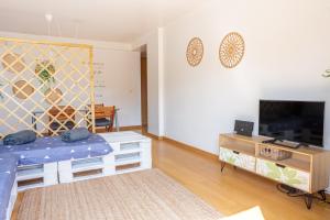 uma sala de estar com uma cama e uma televisão em One Bedroom Apartment with Stunning River Views and Private Rooftop! em Lisboa