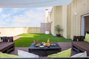 um pátio com uma mesa com comida em One Bedroom Apartment with Stunning River Views and Private Rooftop! em Lisboa