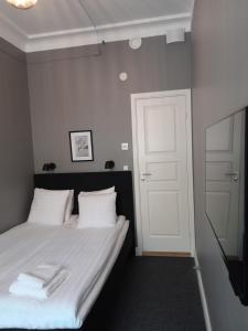 a bedroom with a bed with white sheets and a white door at Birka Hotel in Stockholm