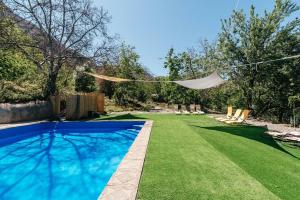 a backyard with a swimming pool and a lawn with chairs at Cabañas El Palomar in San Alfonso