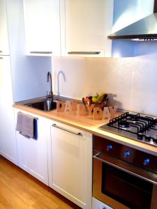 a white kitchen with a sink and a stove at B&B Day by day in Iseo