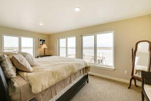 a bedroom with a bed with a view of the ocean at Waterfront Kenai Townhome Less Than 1 Mi to Beach! in Kenai